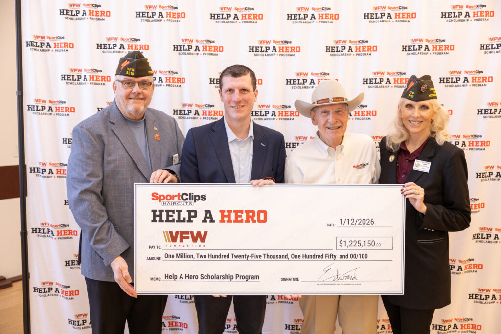Four individuals proudly hold a large check for $1,225,150 supporting the Help A Hero Scholarship Program.
