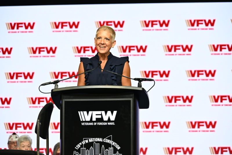 A speaker addresses the audience at the VFW National Convention, emphasizing support for veterans and community engagement.