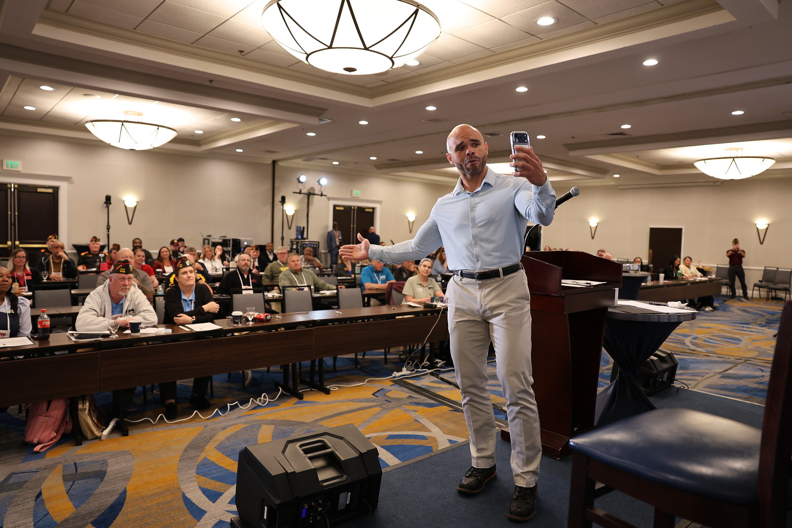 A speaker engages an audience at a conference, highlighting the importance of national programs and support initiatives.