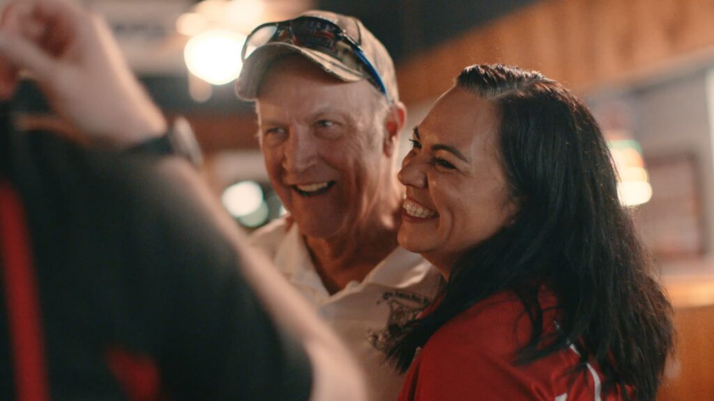 Smiling individuals engage happily in a social setting, reflecting community support and connection related to financial assistance.