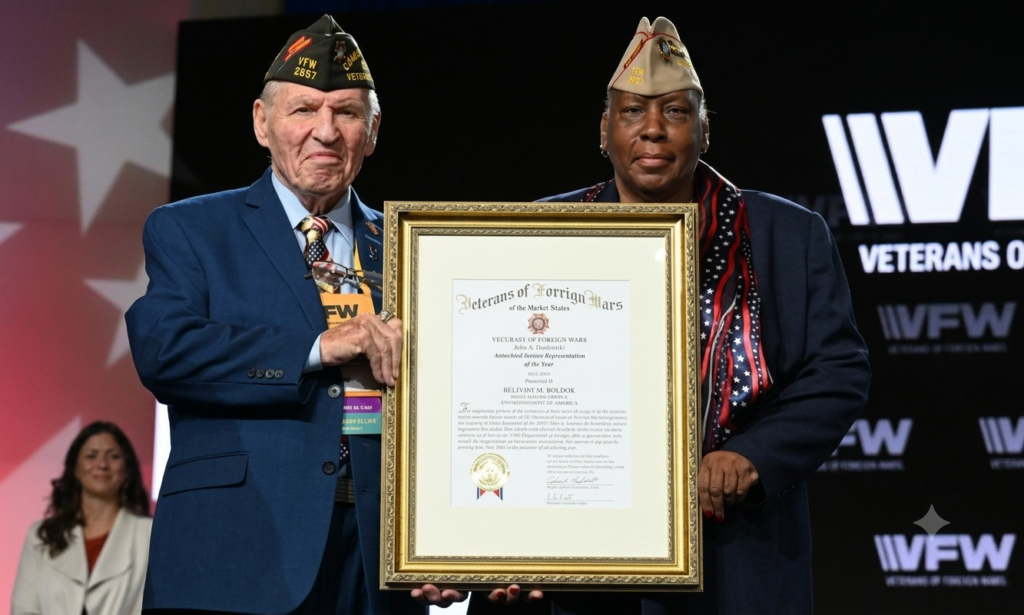 Two veterans proudly hold a framed award recognizing a fellow veteran for their outstanding service and contributions.